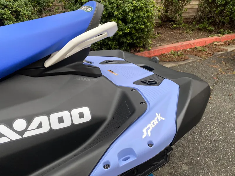 Slide: The Image of 2024 Sea-Doo Spark 3up jet ski, blue and black design, parked outdoors. - 6