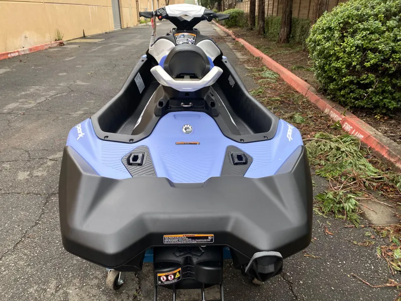 Slide: The Image of 2024 Sea-Doo Spark 3up jet ski in blue, parked on a paved path. - 7