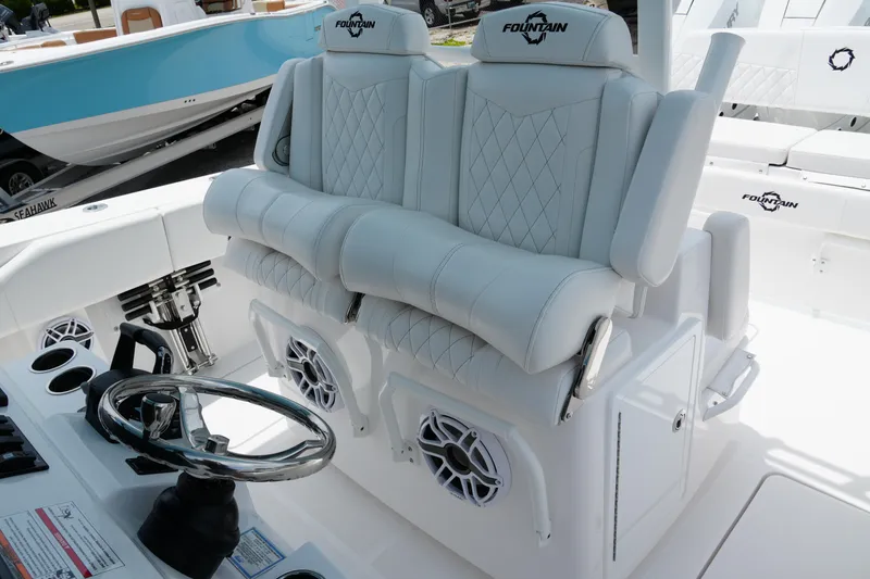 Slide: The Image of 2025 Fountain 38 CC boat interior with luxurious white seating and steering wheel. - 24