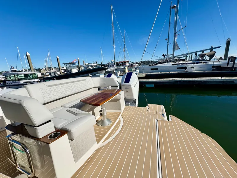 Slide: The Image of 2025 Tiara Yachts 43 LE at marina, featuring elegant seating and wooden table. - 14