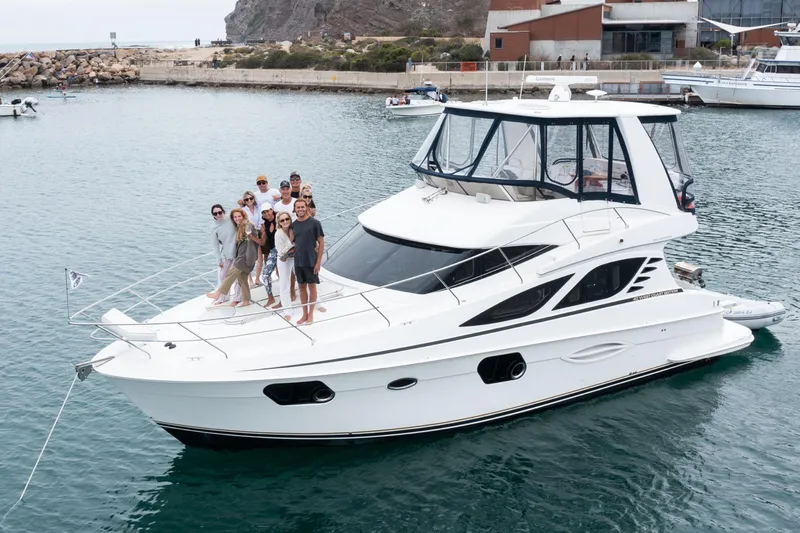 The Image of Group enjoying a 2012 Silverton West Coast Edition yacht in a scenic harbor. - 0