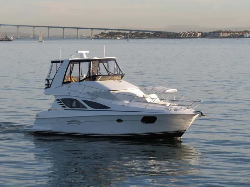 Slide: The Image of 2012 Silverton West Coast Edition yacht cruising on calm waters near a bridge. - 1