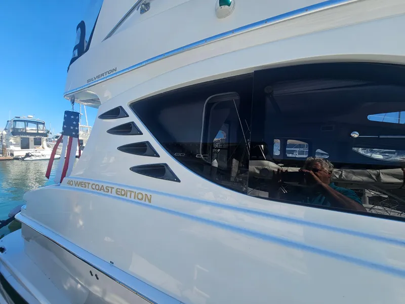 Slide: The Image of 2012 Silverton West Coast Edition yacht docked, featuring sleek design and American flag. - 10