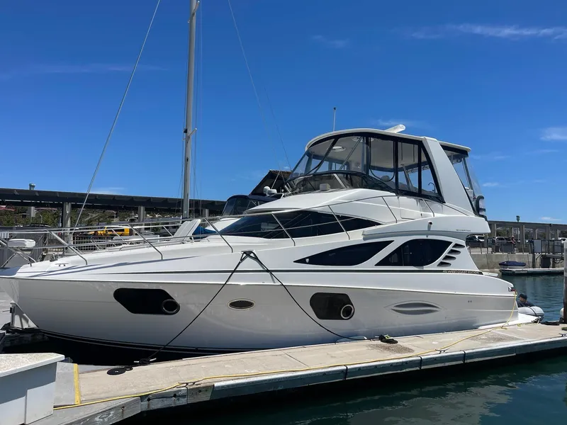 Slide: The Image of 2012 Silverton West Coast Edition yacht docked at marina under clear blue sky. - 2