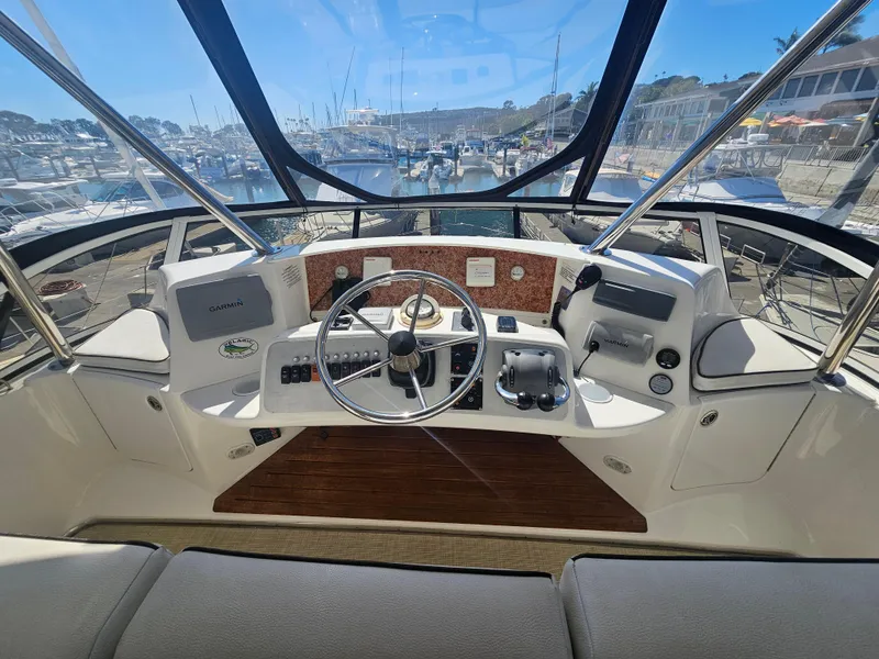Slide: The Image of Silverton 2012 West Coast Edition yacht helm with modern controls and marina view. - 25