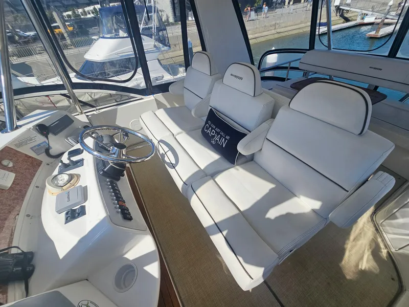Slide: The Image of 2012 Silverton West Coast Edition yacht interior with white seating and steering wheel. - 28