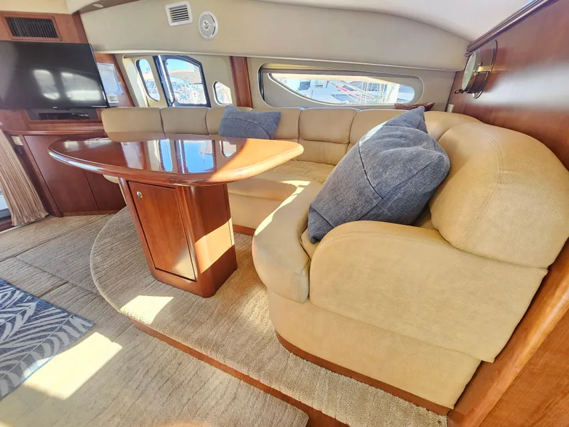 Slide: The Image of Luxurious 2012 Silverton West Coast Edition yacht interior with plush seating and elegant wood table. - 41