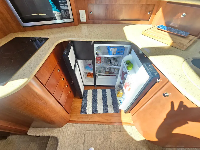 Slide: The Image of 2012 Silverton West Coast Edition yacht kitchen with open fridge and modern amenities. - 43
