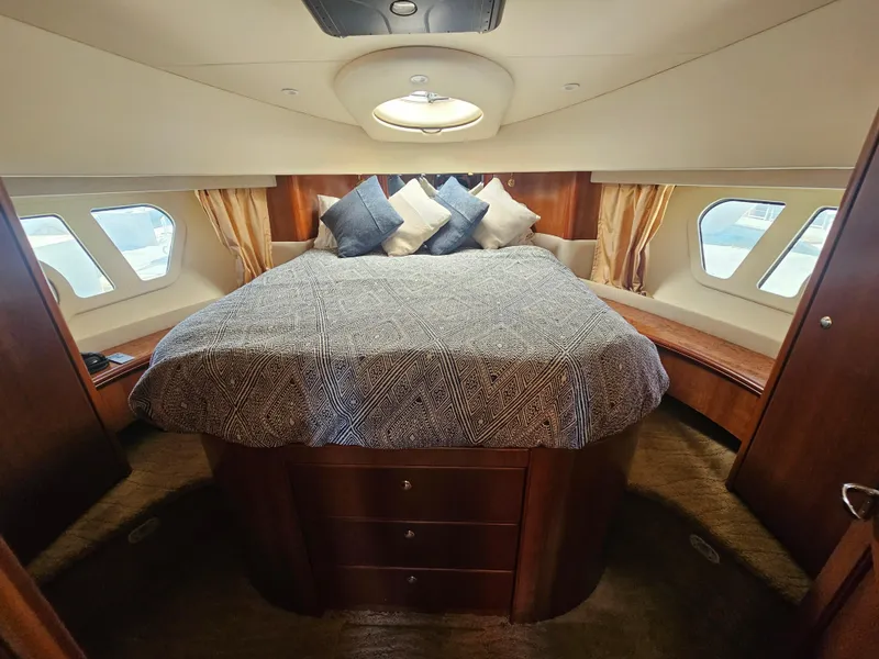 Slide: The Image of Luxurious 2012 Silverton West Coast Edition yacht bedroom with elegant bedding and ample natural light. - 46