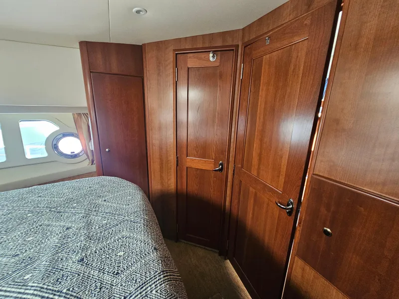 Slide: The Image of Interior of 2012 Silverton West Coast Edition yacht with wooden cabinetry and porthole window. - 49