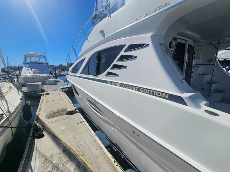 Slide: The Image of 2012 Silverton West Coast Edition yacht docked at marina under clear blue sky. - 7