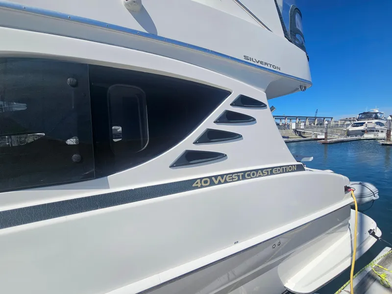Slide: The Image of 2012 Silverton 40 West Coast Edition yacht docked at marina under clear blue sky. - 8