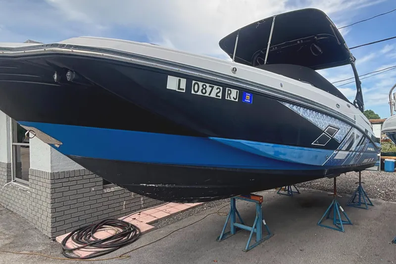 Slide: The Image of 2017 Monterey M65 boat on stands, featuring a sleek black and blue design. - 1