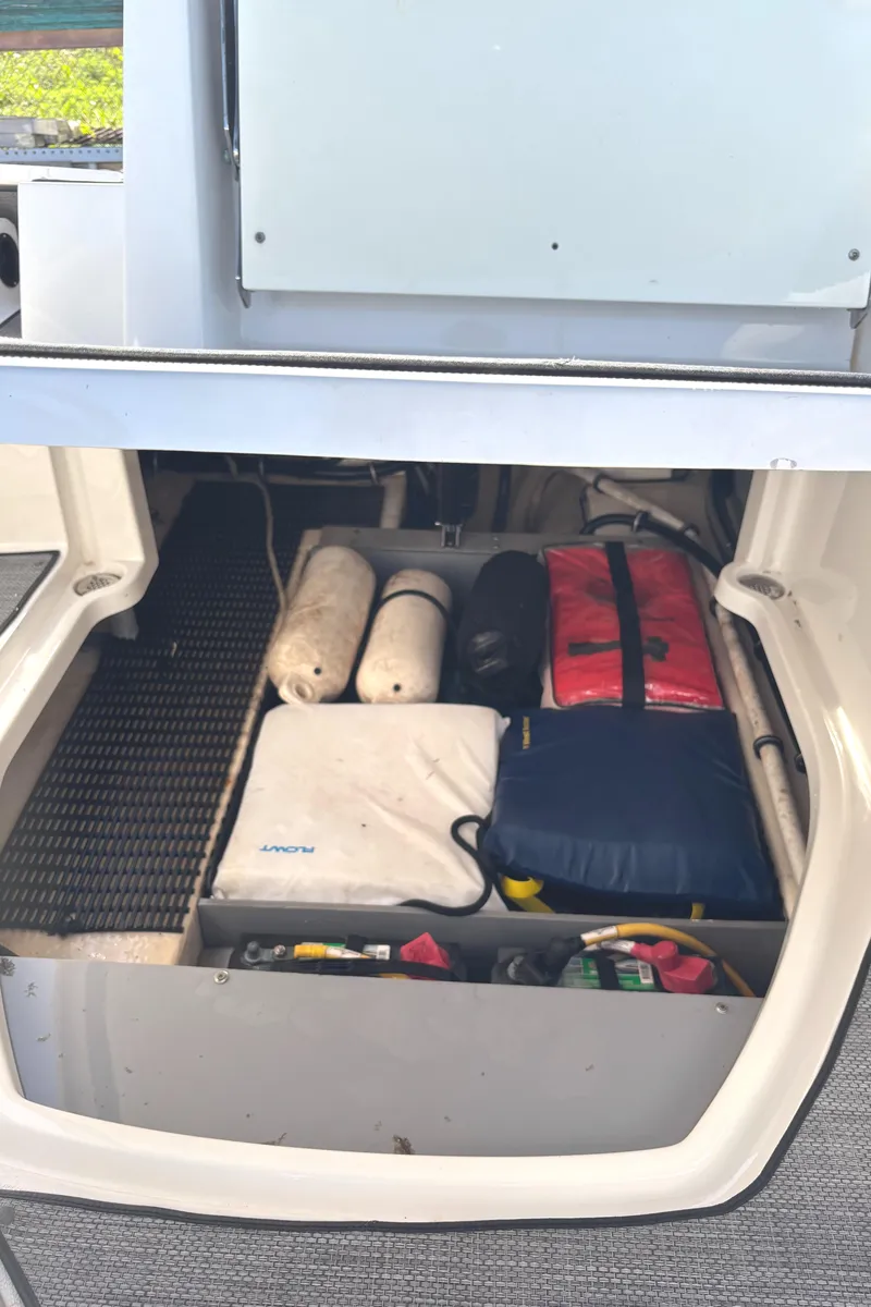 Slide: The Image of Storage compartment in a 2017 Monterey M65 boat, organized with safety gear and equipment. - 10
