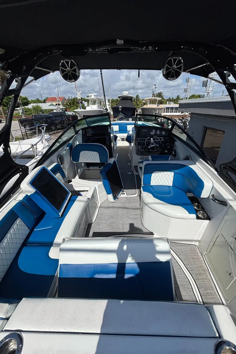 Slide: The Image of Interior of 2017 Monterey M65 boat with blue and white seating, docked under sunny skies. - 8