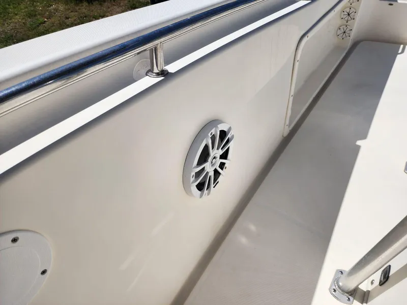 Slide: The Image of 2017 Bulls Bay 230 Center Console boat with open storage compartment, sunny day background. - 23