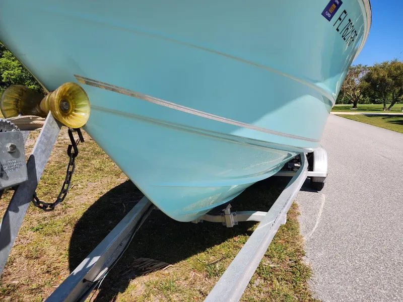 Slide: The Image of 2017 Bulls Bay 230 Center Console boat with T-top, surrounded by lush greenery and clear blue sky. - 38