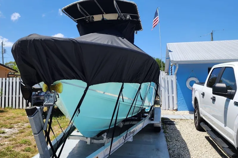 Slide: The Image of 2017 Bulls Bay 230 Center Console boat covered on trailer, American flag in background. - 45