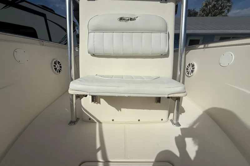Slide: The Image of 2017 Bulls Bay 230 Center Console boat with cushioned seating, palm trees in the background. - 48