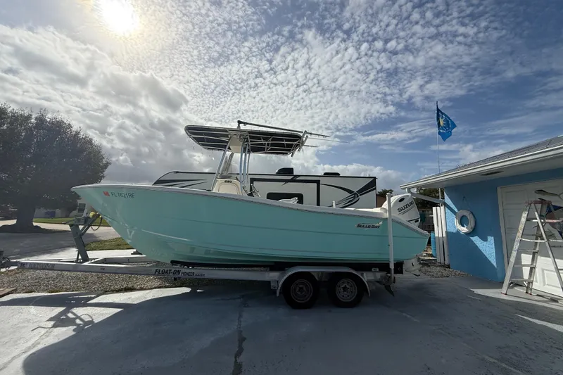 Slide: The Image of 2017 Bulls Bay 230 Center Console boat covered on trailer, parked outdoors. - 60