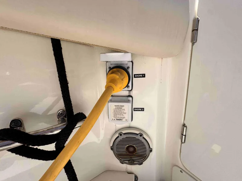 Slide: The Image of Boston Whaler 350 Outrage 2018 shore power connection with yellow cable and speaker. - 17