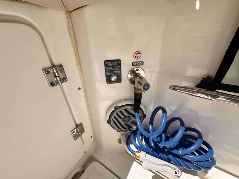 Slide: The Image of 2018 Boston Whaler 350 Outrage boat detail with raw water hose and flush operation instructions. - 18