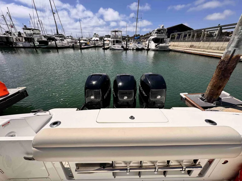Slide: The Image of 2018 Boston Whaler 350 Outrage with triple engines docked in a marina. - 2