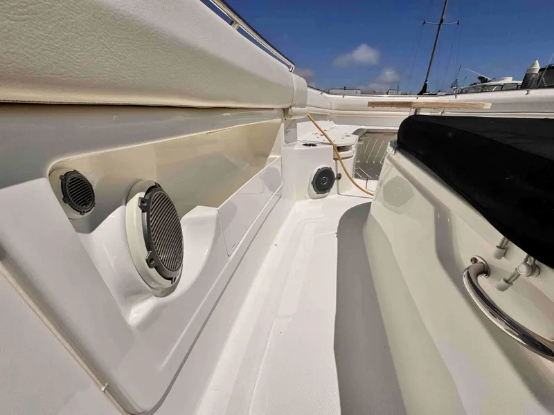 Slide: The Image of 2018 Boston Whaler 350 Outrage interior with speakers and seating, under clear blue sky. - 23