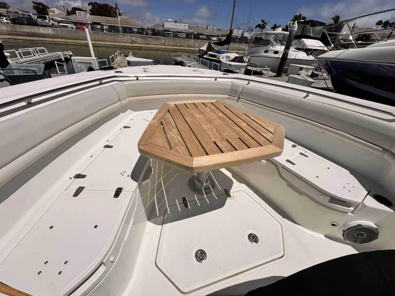 Slide: The Image of 2018 Boston Whaler 350 Outrage boat interior with wooden table, docked in marina. - 24
