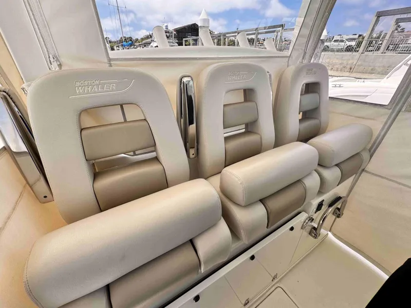Slide: The Image of 2018 Boston Whaler 350 Outrage interior seating, featuring luxurious beige upholstery. - 27