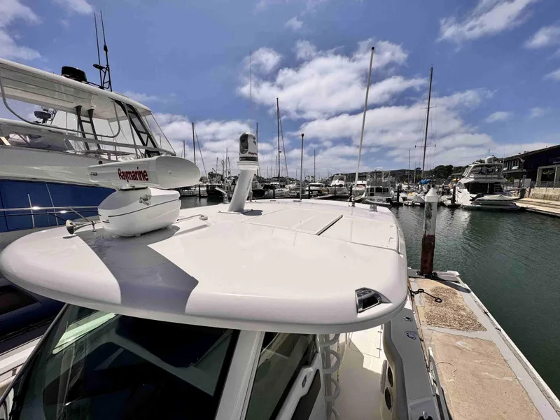 Slide: The Image of 2018 Boston Whaler 350 Outrage docked in a marina under a partly cloudy sky. - 44