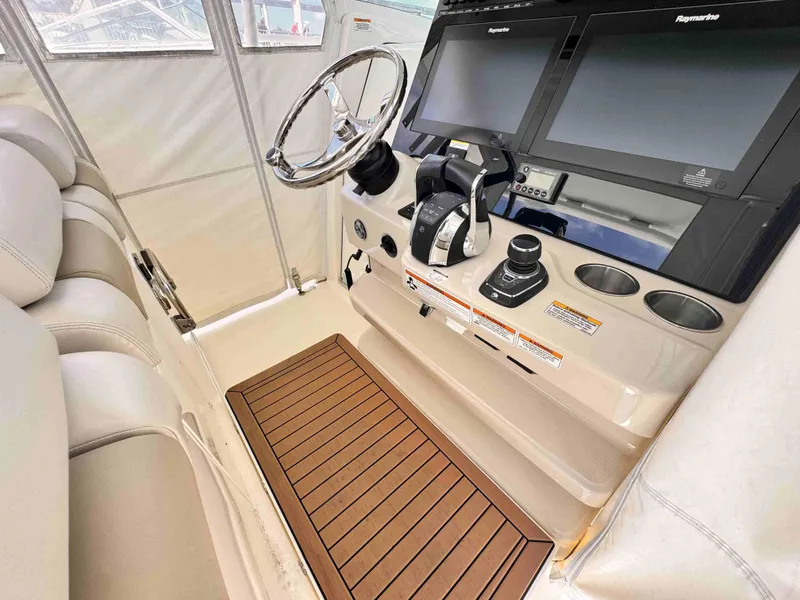 Slide: The Image of 2018 Boston Whaler 350 Outrage helm with dual Raymarine displays and teak flooring. - 46