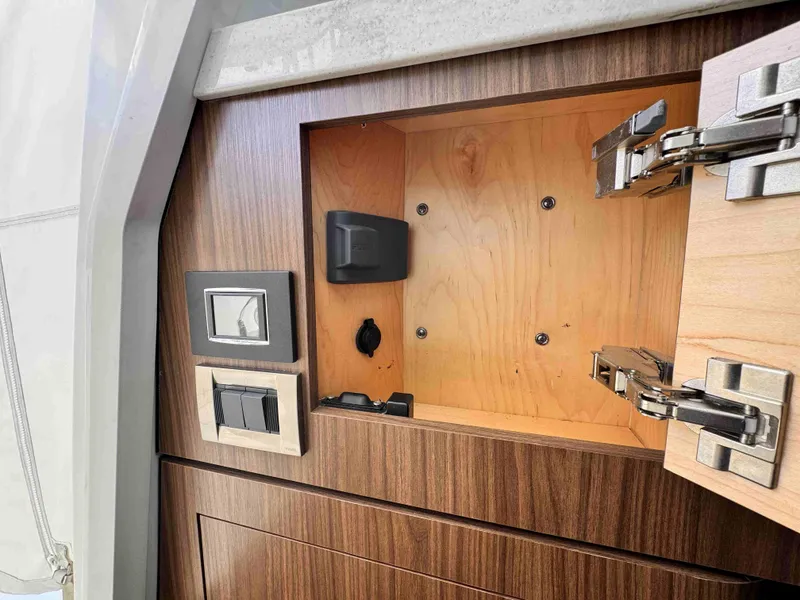 Slide: The Image of Open wooden cabinet on 2018 Boston Whaler 350 Outrage boat, showing interior and hardware. - 48