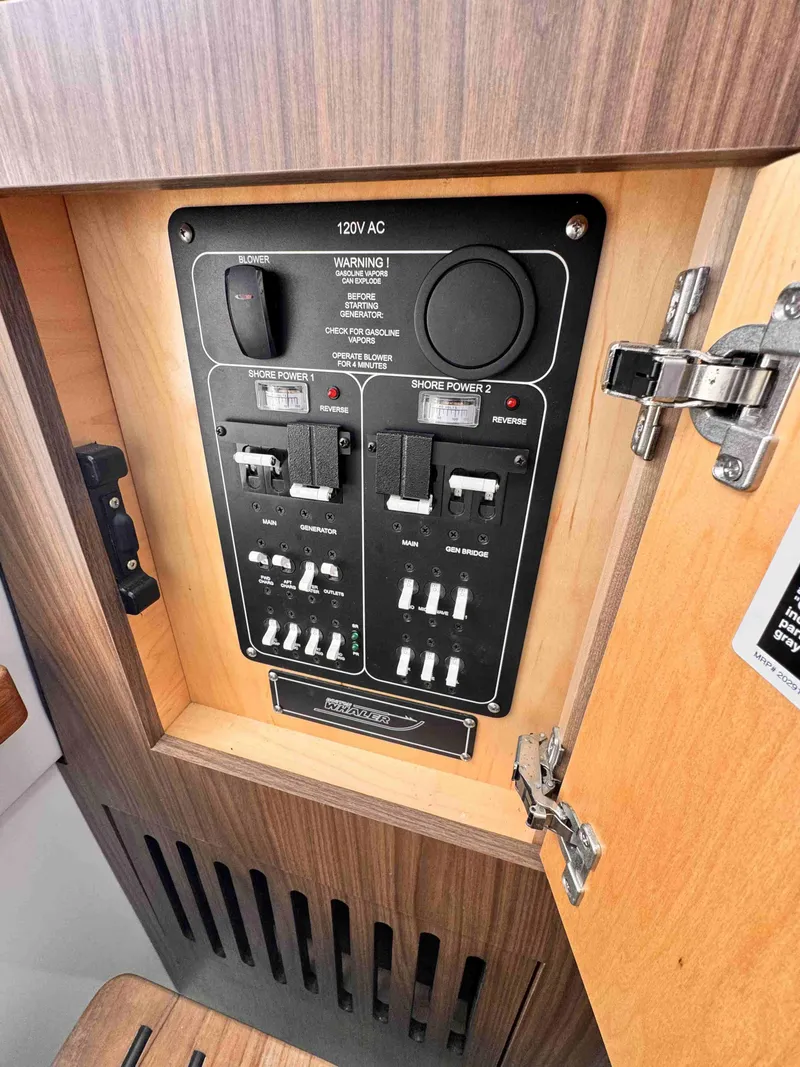 Slide: The Image of Electrical panel of 2018 Boston Whaler 350 Outrage boat, featuring shore power controls. - 49