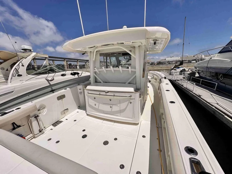 Slide: The Image of 2018 Boston Whaler 350 Outrage boat docked, showcasing spacious deck and sleek design. - 6