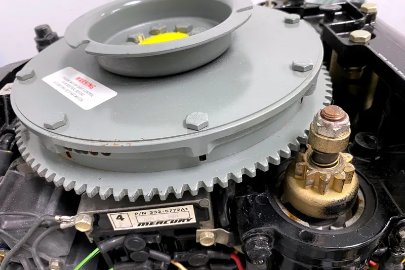 Slide: The Image of Close-up of a 1963 Chincoteague Scow engine component with visible gears and warning label. - 4