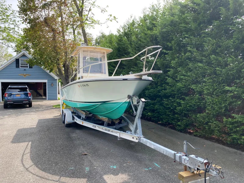 Slide: The Image of 1982 Mako 23 Inboard Diesel boat on trailer in driveway near garage. - 13