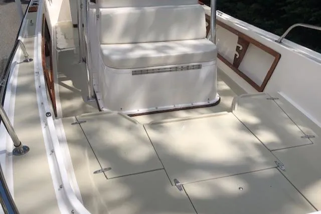 Slide: The Image of 1982 Mako 23 Inboard Diesel boat deck with seating and storage compartments. - 17