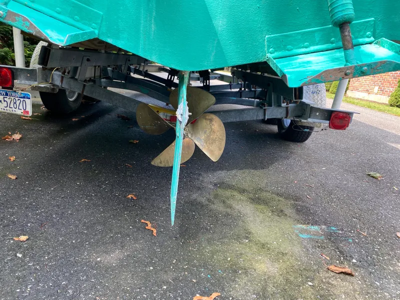 Slide: The Image of 1982 Mako 23 Inboard Diesel boat on trailer, showing propeller and hull. - 18
