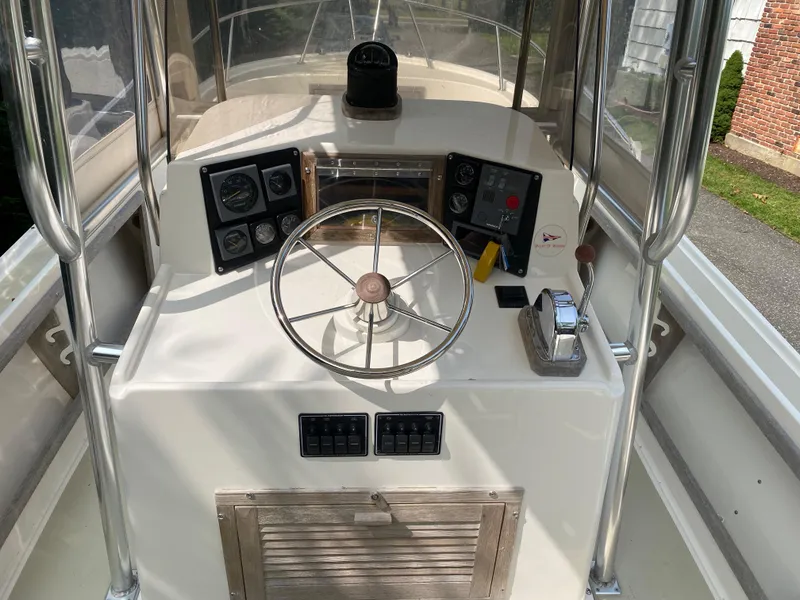 Slide: The Image of 1982 Mako 23 Inboard Diesel boat dashboard with steering wheel and control panel. - 19