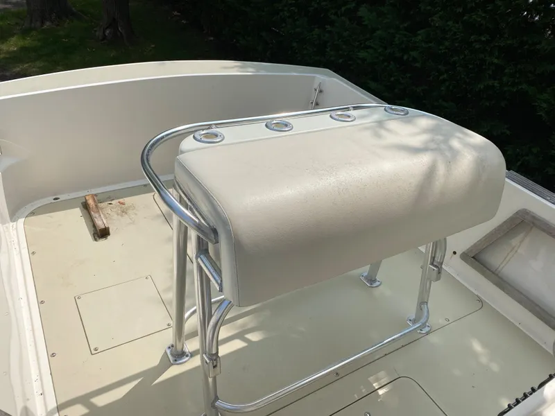 Slide: The Image of 1982 Mako 23 Inboard Diesel boat with cushioned seating and metal frame. - 27