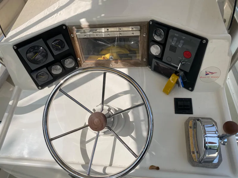 Slide: The Image of 1982 Mako 23 Inboard Diesel boat dashboard with steering wheel and control panels. - 31