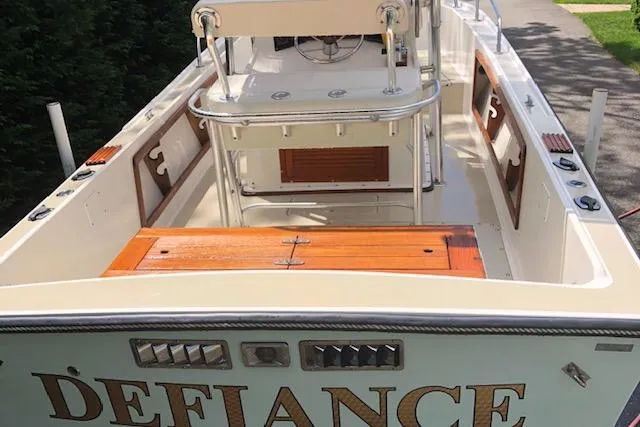 Slide: The Image of 1982 Mako 23 Inboard Diesel boat, rear view with "Defiance" name, wooden deck, and control panel. - 6