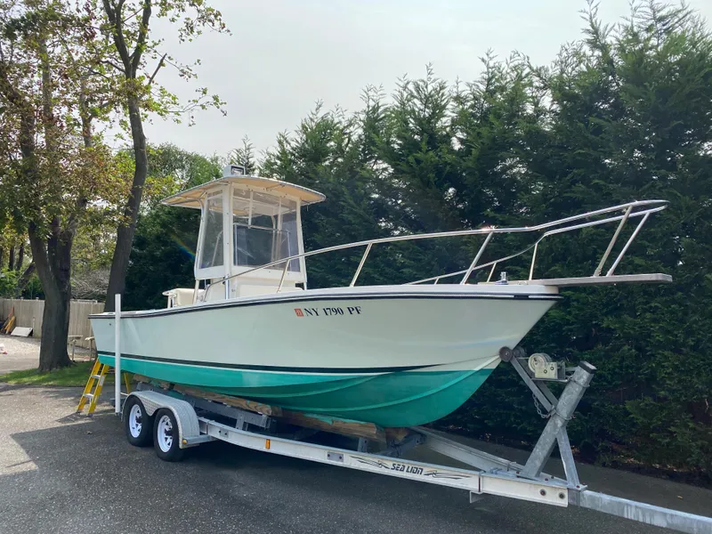 Slide: The Image of 1982 Mako 23 Inboard Diesel boat on trailer, parked outdoors near trees. - 8