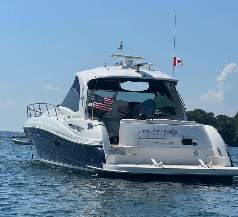 Slide: The Image of 2005 Sea Ray 500 Sundancer yacht on water, displaying American and Canadian flags. - 1