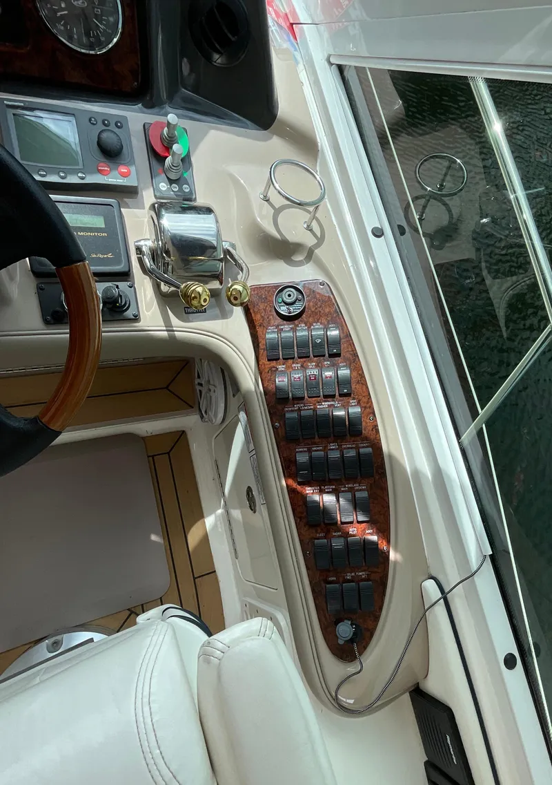 Slide: The Image of Control panel of a 2005 Sea Ray 500 Sundancer yacht with switches and steering wheel. - 13