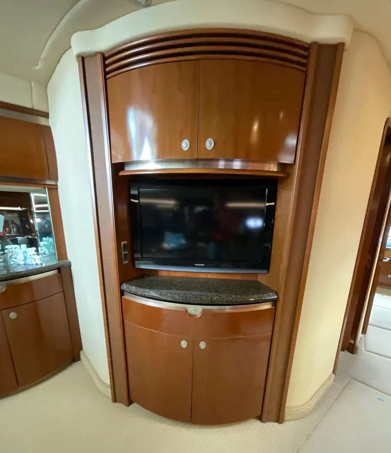 Slide: The Image of Luxurious interior of 2005 Sea Ray 500 Sundancer with built-in TV and wooden cabinetry. - 16