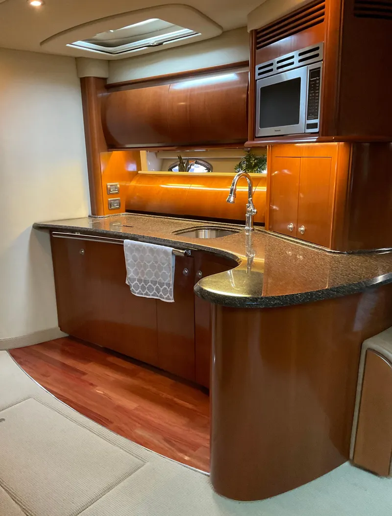 Slide: The Image of Luxurious 2005 Sea Ray 500 Sundancer yacht kitchen with sleek wood cabinetry and modern appliances. - 18