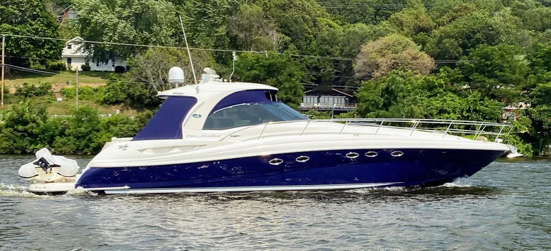 Slide: The Image of 2005 Sea Ray 500 Sundancer yacht cruising on a river with lush green background. - 2