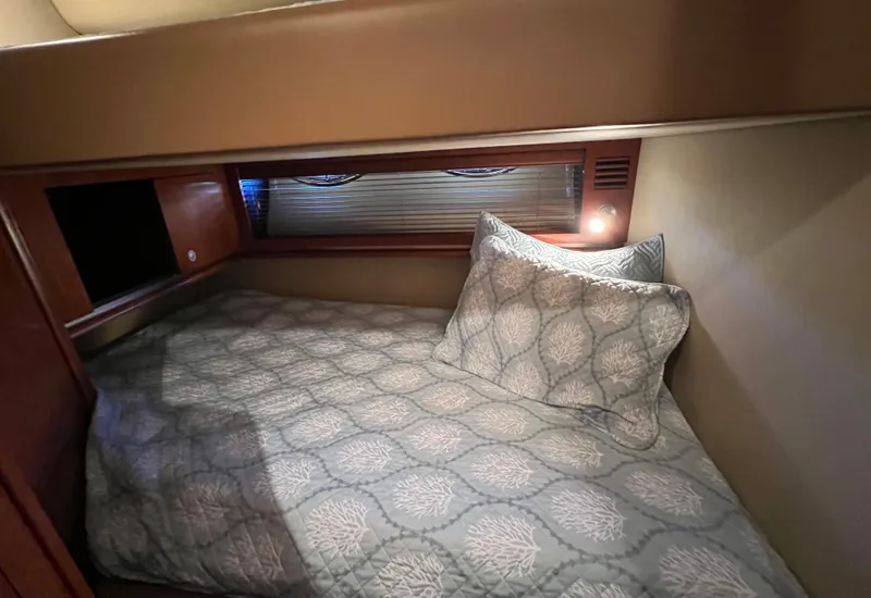Slide: The Image of Cozy cabin bed in 2005 Sea Ray 500 Sundancer yacht with patterned bedding. - 22